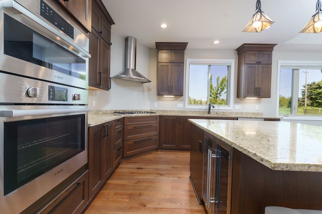 10408 Stoney Point Dr, South Lyon, MI 48178 - kitchen featuring wall chimney range hood, healthy amount of natural light, light wood-style floors, beverage cooler, and recessed lighting