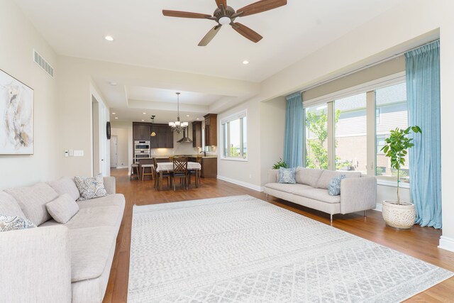 10408 Stoney Point Dr, South Lyon, MI 48178 - living room with wood finished floors, a raised ceiling, a chandelier, baseboards, and recessed lighting