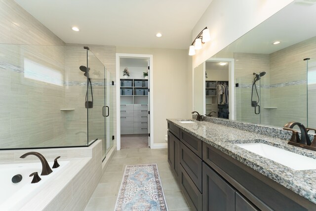 10408 Stoney Point Dr, South Lyon, MI 48178 - full bathroom featuring a shower stall, a spacious closet, a relaxing tiled tub, tile patterned floors, and double vanity