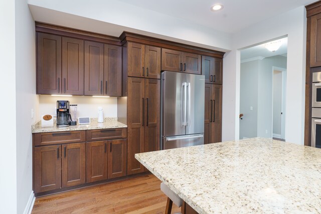 10408 Stoney Point Dr, South Lyon, MI 48178 - kitchen featuring stainless steel appliances, light wood-style floors, recessed lighting, and light stone counters