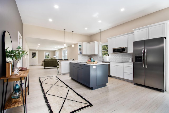 3401 Hicks Ave, Benton Harbor, MI 49022 - kitchen featuring stainless steel appliances, white cabinets, tasteful backsplash, light countertops, and light wood-style flooring