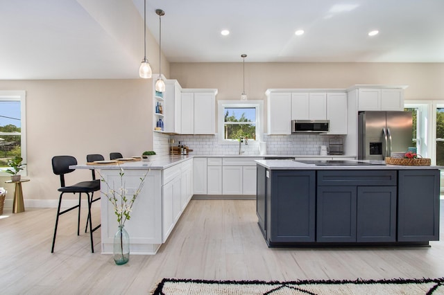 3401 Hicks Ave, Benton Harbor, MI 49022 - kitchen featuring appliances with stainless steel finishes, white cabinets, tasteful backsplash, a center island, and light wood finished floors