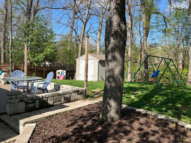 view of yard with a playground, a storage unit, a patio, an outdoor structure, and outdoor dining area