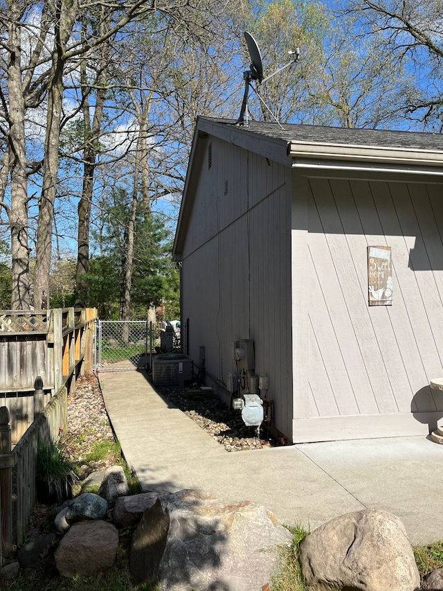 view of property exterior featuring fence, a gate, and a shingled roof