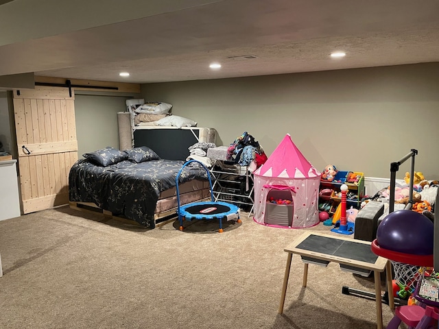 carpeted bedroom featuring a barn door and recessed lighting