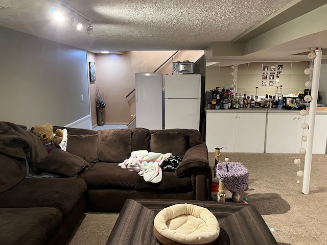 living room featuring carpet flooring, a textured ceiling, stairs, and baseboards