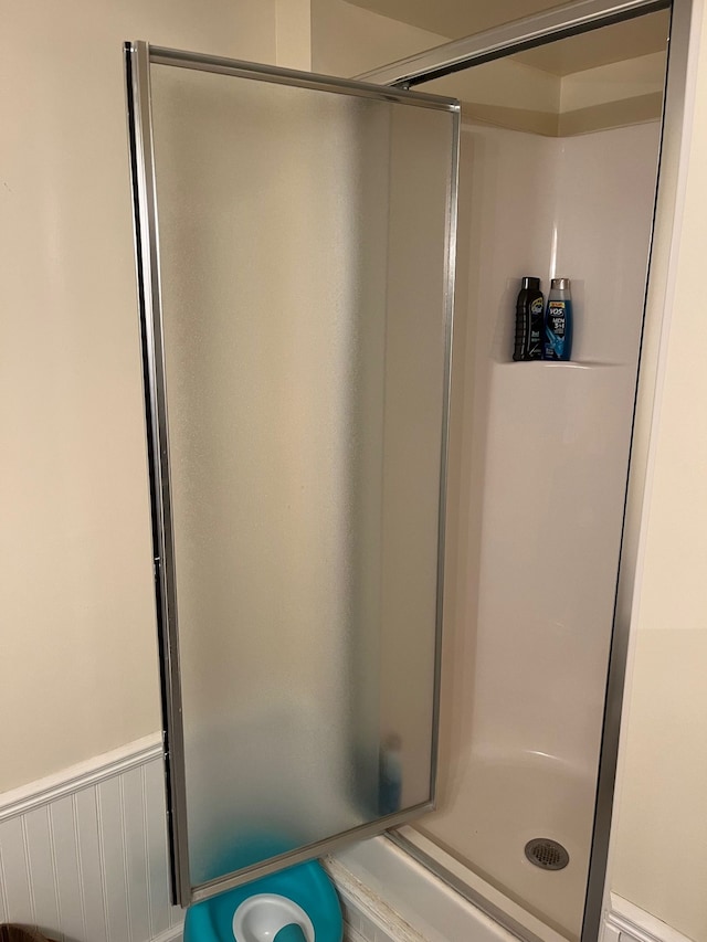 bathroom with a stall shower and wainscoting