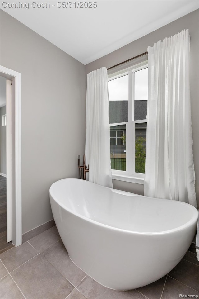 4280 Rolling Meadow Ln, Ypsilanti, MI 48197 - bathroom with tile patterned floors, a soaking tub, and baseboards
