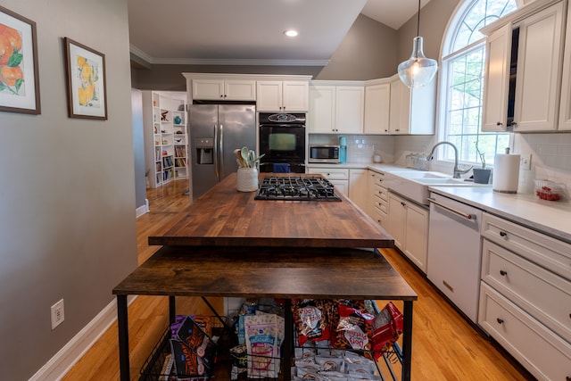 5100 Perry Rd, Grand Blanc, MI 48439 - kitchen with black appliances, wooden counters, a sink, light wood-style flooring, and ornamental molding