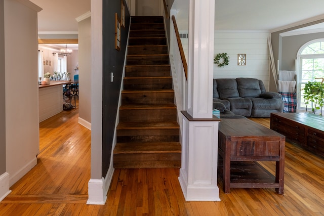 5100 Perry Rd, Grand Blanc, MI 48439 - staircase with wood finished floors, ornamental molding, a chandelier, baseboards, and wooden walls