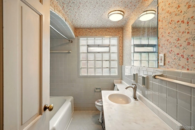 2332 Nolen Dr, Flint, MI 48504 - full bathroom with wallpapered walls, tile walls, toilet, vanity, and shower / bath combination