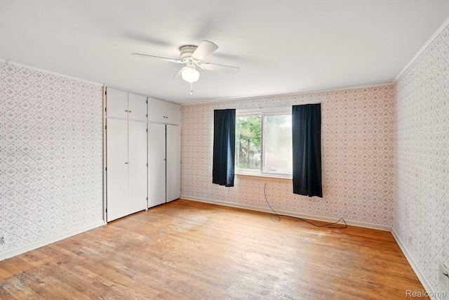 2332 Nolen Dr, Flint, MI 48504 - unfurnished bedroom with wallpapered walls, light wood-type flooring, baseboards, a ceiling fan, and crown molding