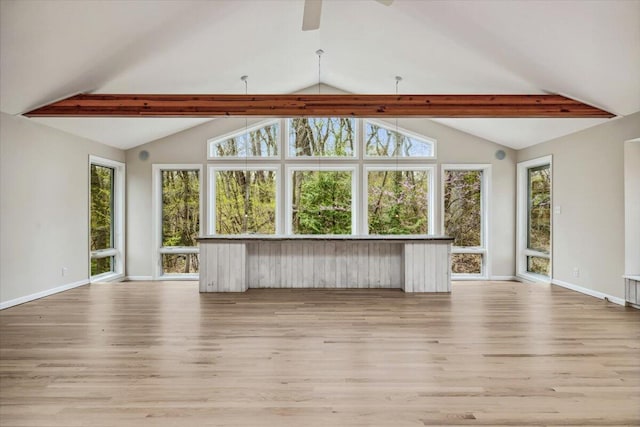 unfurnished living room with beamed ceiling, light wood finished floors, ceiling fan, baseboards, and high vaulted ceiling