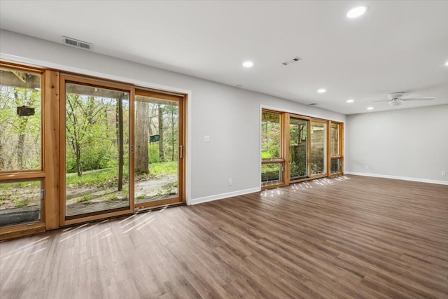 unfurnished room featuring baseboards, plenty of natural light, wood finished floors, and recessed lighting
