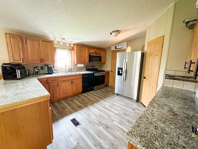 1076 N Lakeshore Rd, Harbor Beach, MI 48441 - kitchen featuring appliances with stainless steel finishes, a sink, a textured ceiling, light wood finished floors, and light countertops