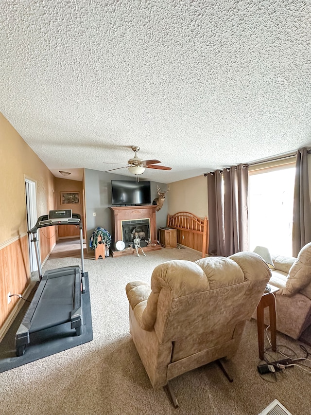 1076 N Lakeshore Rd, Harbor Beach, MI 48441 - carpeted living room featuring a textured ceiling, ceiling fan, and a fireplace