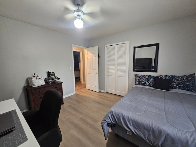 bedroom featuring light wood finished floors, baseboards, an office area, a closet, and a ceiling fan