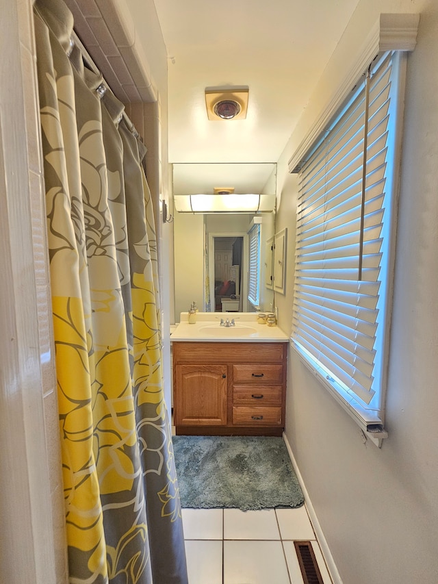 full bathroom with tile patterned floors, vanity, baseboards, and a shower with curtain