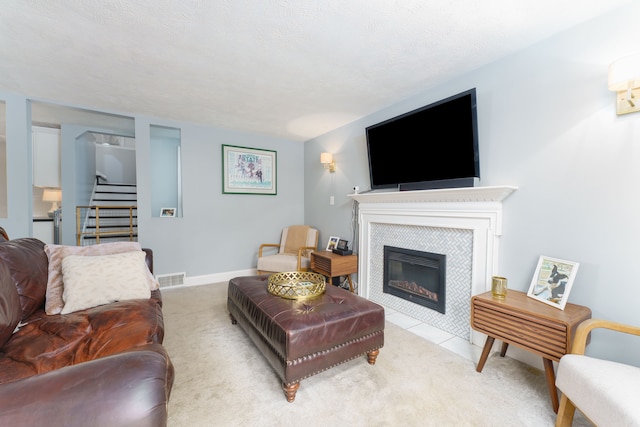 466 Wayland Ave, East Lansing, MI 48823 - living room with stairs, a tiled fireplace, light colored carpet, and baseboards