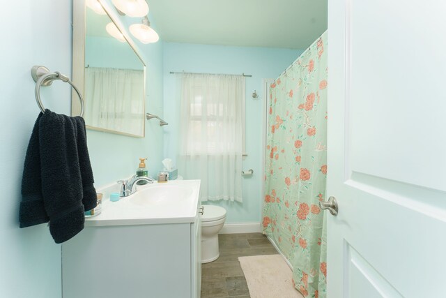 466 Wayland Ave, East Lansing, MI 48823 - bathroom featuring wood finished floors, toilet, vanity, baseboards, and a shower with shower curtain