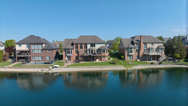 54545 Pelican Ln, Shelby Twp, MI 48315 - back of house with a residential view, a water view, stairway, and a lawn