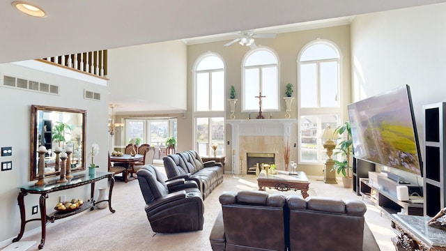 54545 Pelican Ln, Shelby Twp, MI 48315 - carpeted living area featuring a ceiling fan, crown molding, a towering ceiling, plenty of natural light, and a premium fireplace