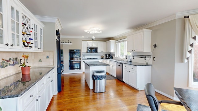 54545 Pelican Ln, Shelby Twp, MI 48315 - kitchen featuring stainless steel appliances, a sink, backsplash, white cabinets, and light wood-style floors
