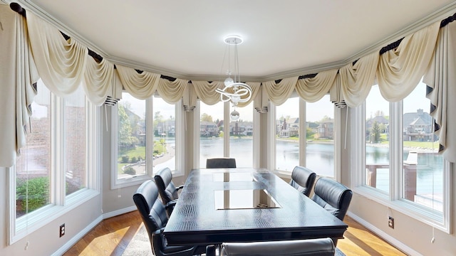 54545 Pelican Ln, Shelby Twp, MI 48315 - dining room featuring baseboards, light wood-type flooring, a water view, and a chandelier