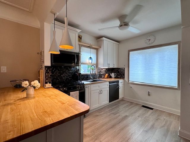 95 Mapleton Rd, Grosse Pointe Farms, MI 48236 - kitchen with black appliances, a sink, wood counters, decorative backsplash, and a ceiling fan