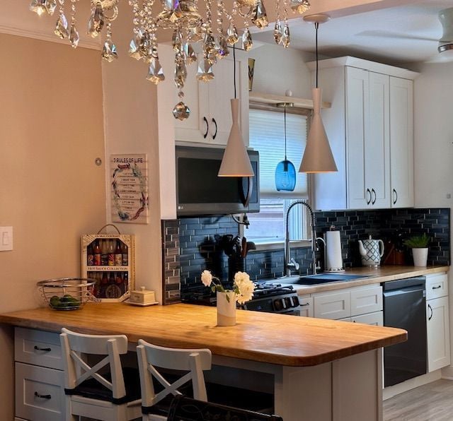 95 Mapleton Rd, Grosse Pointe Farms, MI 48236 - kitchen featuring wood counters, stainless steel microwave, black dishwasher, a sink, and tasteful backsplash