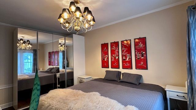 95 Mapleton Rd, Grosse Pointe Farms, MI 48236 - bedroom featuring a chandelier, ornamental molding, and a closet