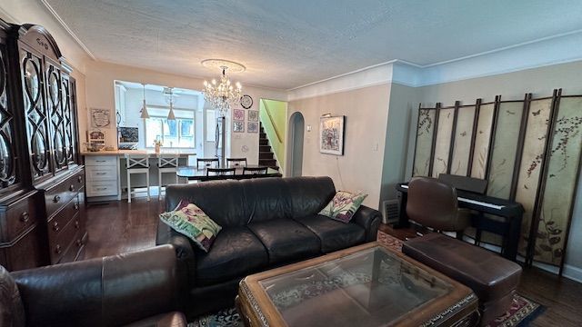 95 Mapleton Rd, Grosse Pointe Farms, MI 48236 - living room featuring dark wood-type flooring, arched walkways, a chandelier, stairway, and a textured ceiling