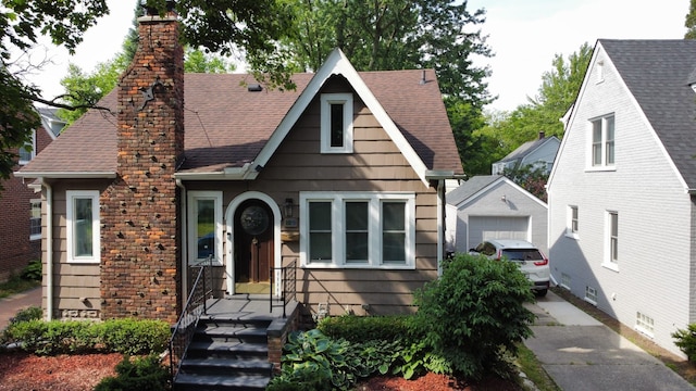 95 Mapleton Rd, Grosse Pointe Farms, MI 48236 - tudor house featuring a chimney, an outbuilding, a shingled roof, and a garage