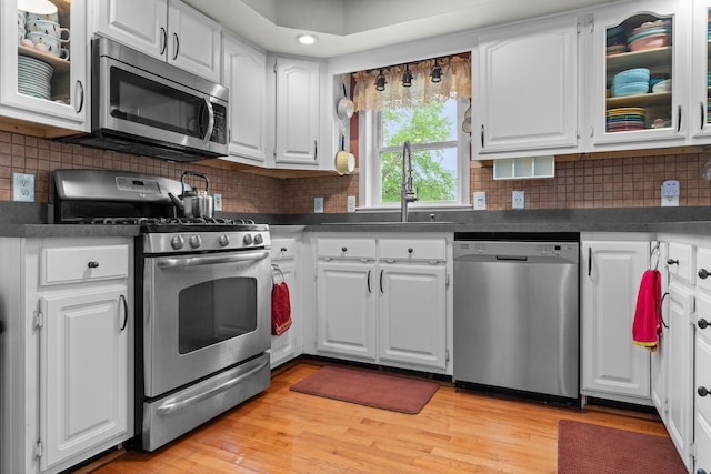 336 Jonesville Rd, Jonesville, MI 49250 - kitchen with stainless steel appliances, a sink, dark countertops, and white cabinets