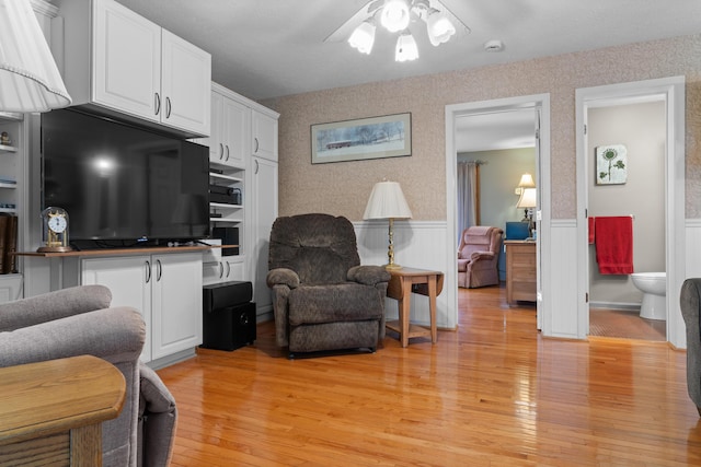336 Jonesville Rd, Jonesville, MI 49250 - living room with ceiling fan, light wood-style flooring, and a wainscoted wall