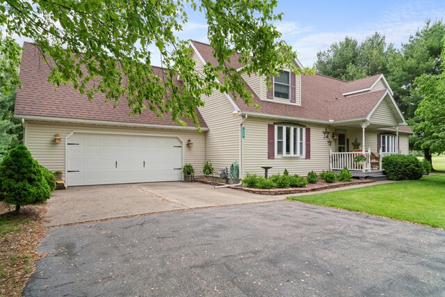 336 Jonesville Rd, Jonesville, MI 49250 - cape cod house featuring asphalt driveway, roof with shingles, a front yard, a garage, and a porch