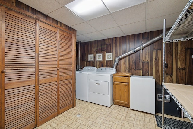 11928 Shenandoah Unit 3, South Lyon, MI 48178 - laundry room featuring cabinet space, washer and dryer, wooden walls, and brick patterned floors