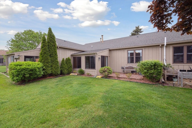 11928 Shenandoah Unit 3, South Lyon, MI 48178 - rear view of house featuring a lawn and roof with shingles