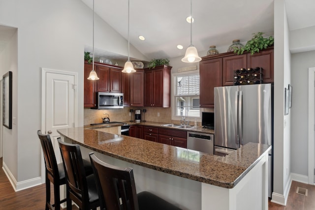 416 Enclave Ct SE Unit 2, Grand Rapids, MI 49546 - kitchen featuring stainless steel appliances, a sink, baseboards, dark wood-style floors, and vaulted ceiling