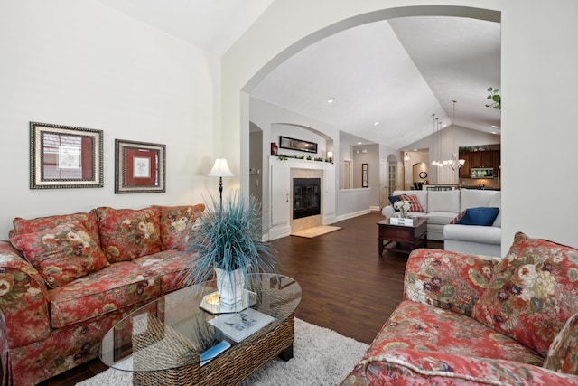 416 Enclave Ct SE Unit 2, Grand Rapids, MI 49546 - living room featuring lofted ceiling, dark wood-style flooring, arched walkways, baseboards, and a fireplace with flush hearth