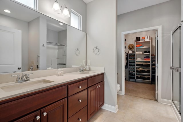 416 Enclave Ct SE Unit 2, Grand Rapids, MI 49546 - bathroom featuring a shower stall, double vanity, tile patterned flooring, a walk in closet, and baseboards