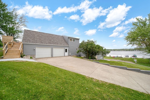 282 Evans Trl, Tipton, MI 49287 - view of front of house featuring a front lawn, a garage, a water view, driveway, and roof with shingles