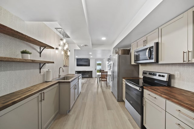282 Evans Trl, Tipton, MI 49287 - kitchen featuring wooden counters, stainless steel appliances, a sink, open shelves, and light wood finished floors