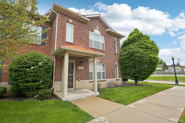 781 2nd St Unit 61, Wyandotte, MI 48192 - view of front of home with brick siding and a front yard