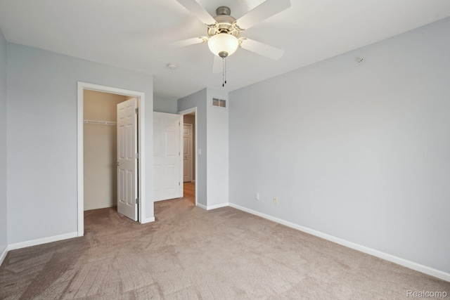 781 2nd St Unit 61, Wyandotte, MI 48192 - unfurnished bedroom featuring carpet flooring, a closet, a walk in closet, baseboards, and ceiling fan