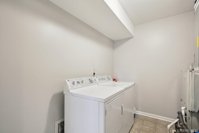781 2nd St Unit 61, Wyandotte, MI 48192 - washroom featuring washer and clothes dryer, baseboards, and light tile patterned floors