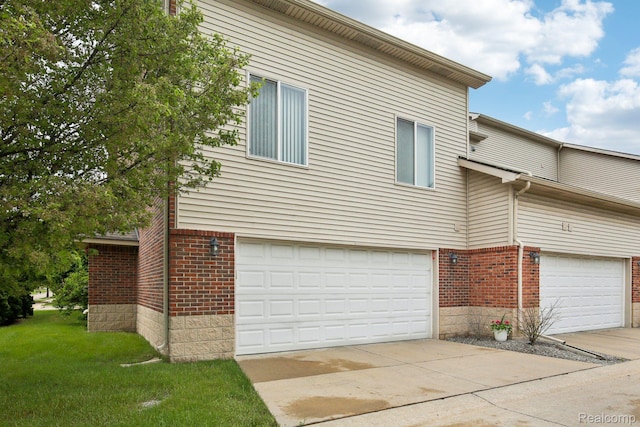 781 2nd St Unit 61, Wyandotte, MI 48192 - view of property exterior featuring brick siding, a garage, a yard, and driveway