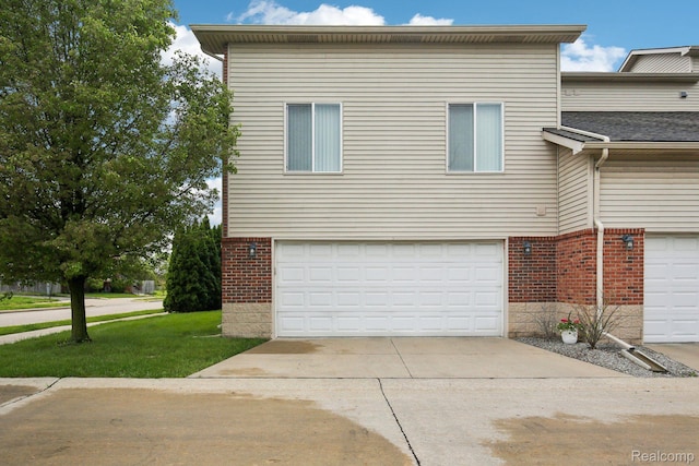 781 2nd St Unit 61, Wyandotte, MI 48192 - view of front of property with brick siding, an attached garage, driveway, and a front yard