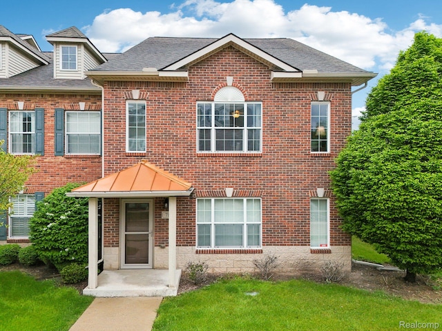 781 2nd St Unit 61, Wyandotte, MI 48192 - view of front of property featuring brick siding, roof with shingles, and a front lawn