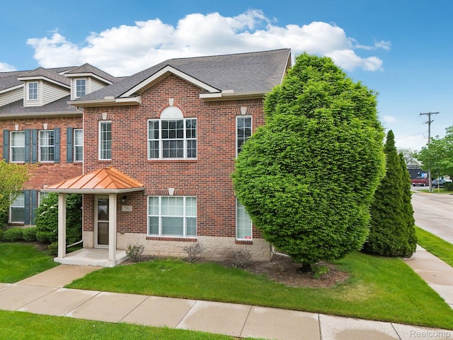781 2nd St Unit 61, Wyandotte, MI 48192 - view of front facade with brick siding, a front yard, and roof with shingles